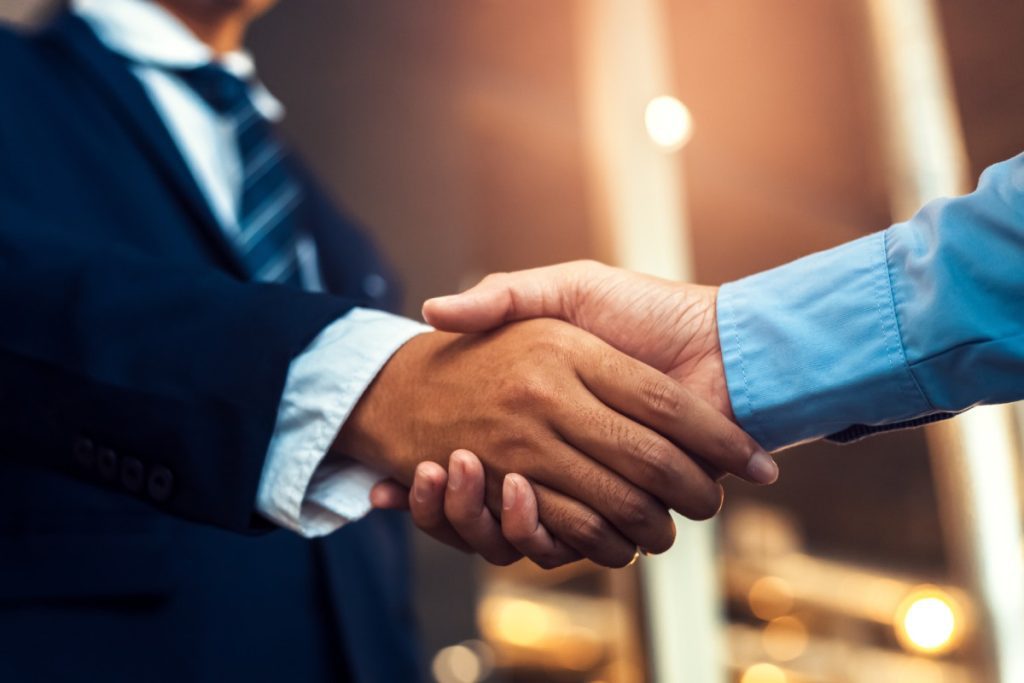 A policyholder shaking hands with an insurance attorney after a consultation regarding a property insurance damage claim.