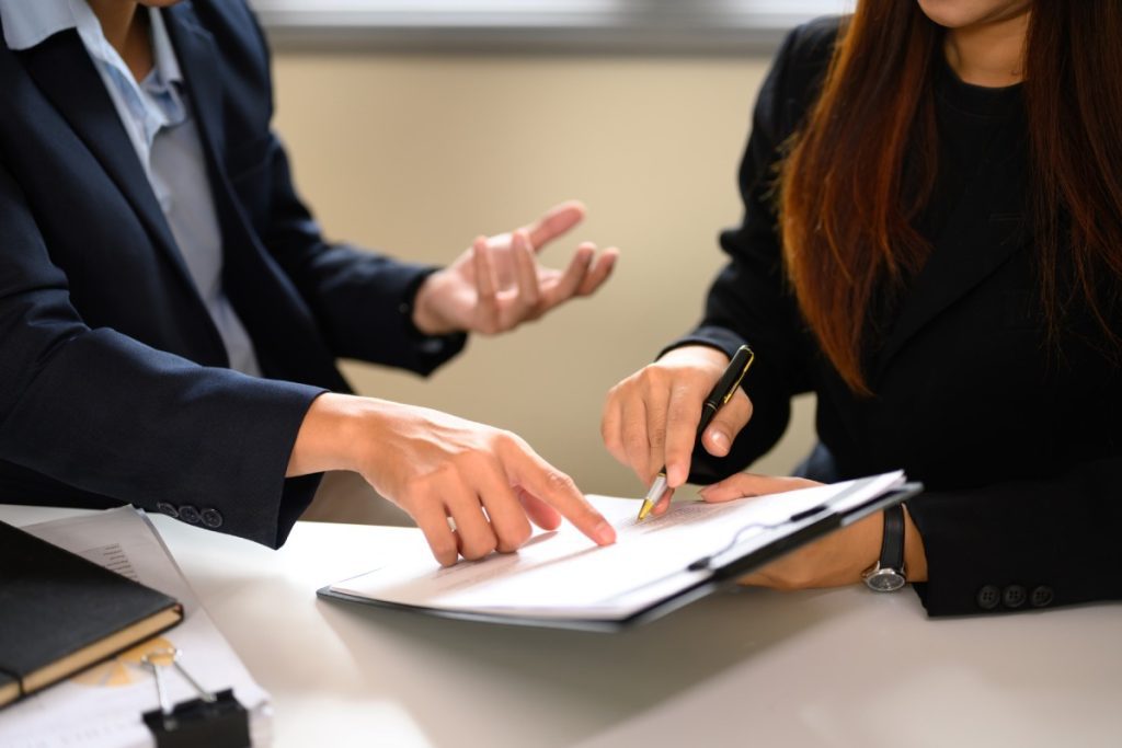 Lawyer and client reviewing documents together to settle an insurance coverage dispute.